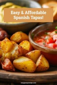 A plate of budget-friendly Spanish tapas featuring crispy roasted potatoes and a bowl of fresh tomato salsa.