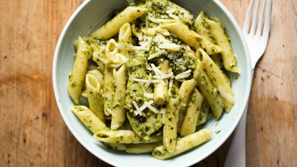 Penne pasta with pesto sauce and cheese.