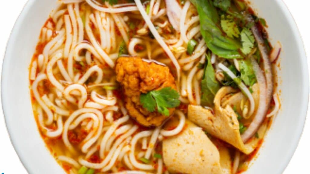 Spicy noodle soup with vegetables and herbs.