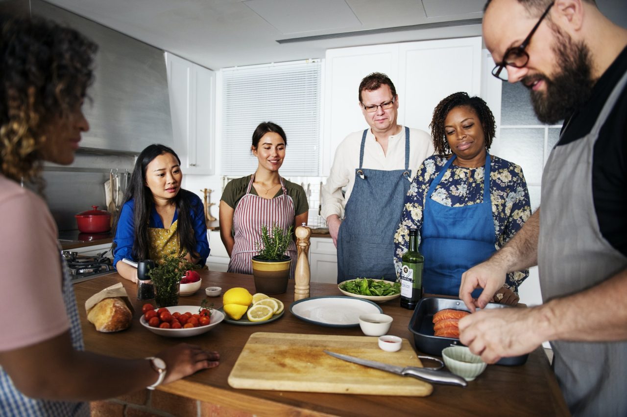 Group cooking class in kitchen preparing ingredients