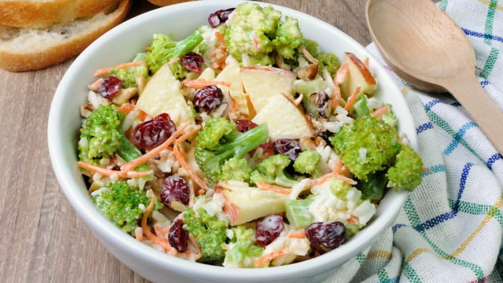Bowl of fresh broccoli salad with bread.