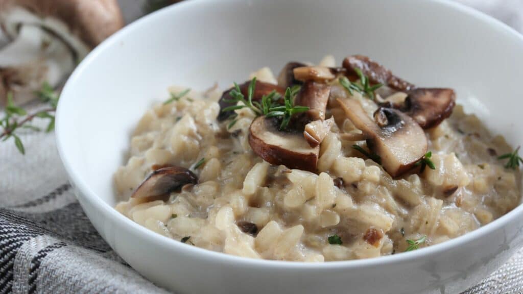 Creamy mushroom risotto in a white bowl.