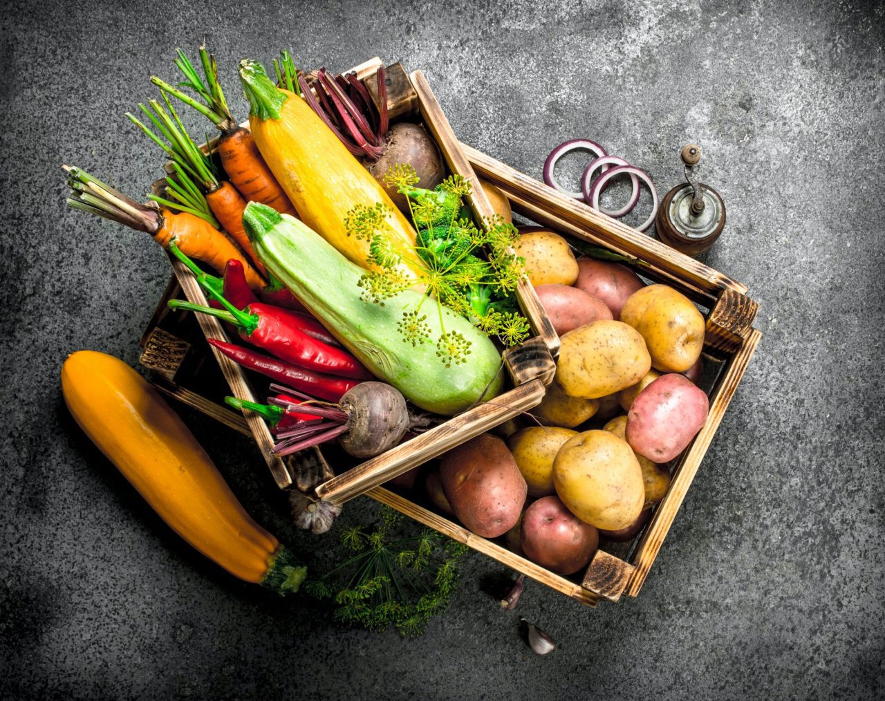 Wooden crates with fresh vegetables on table