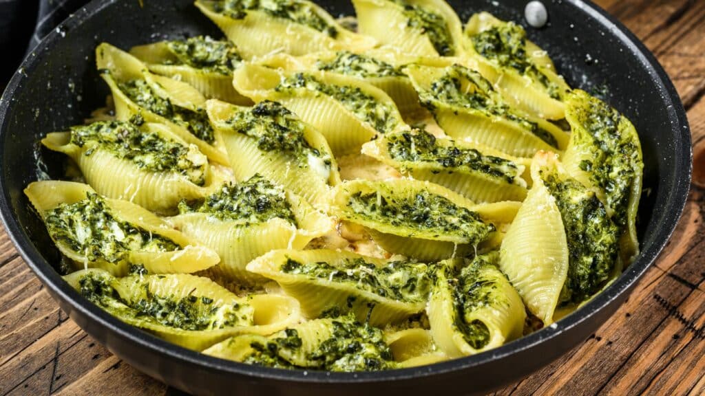 Stuffed pasta shells with spinach and cheese in skillet