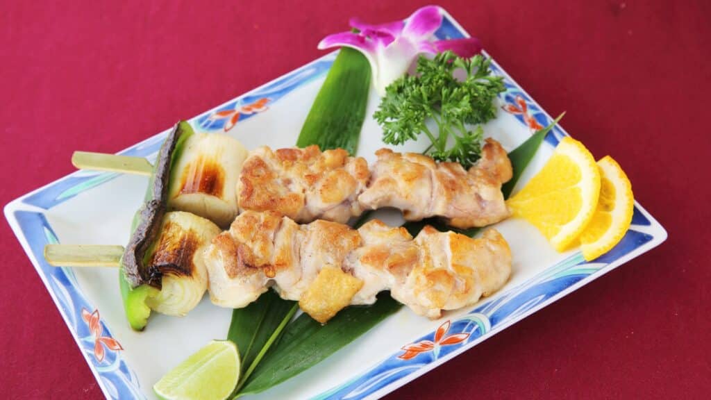 Grilled chicken skewers with vegetables and orange slices
