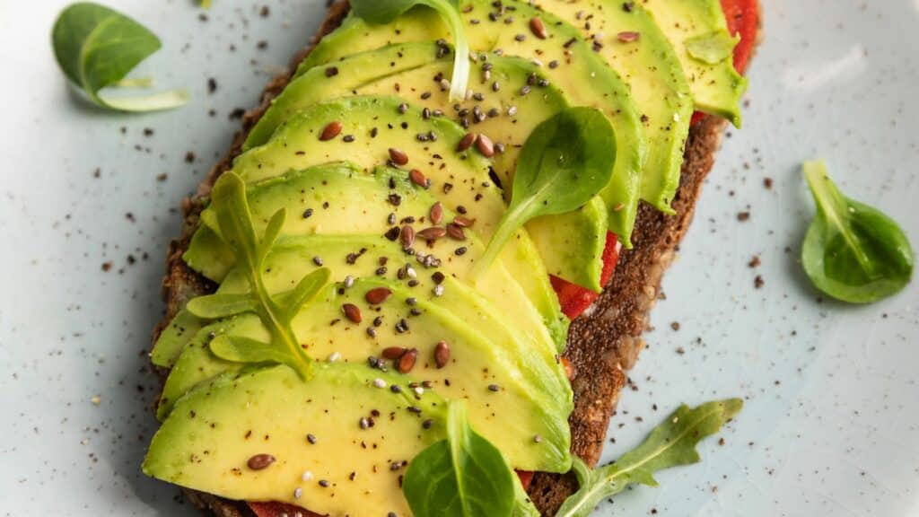 Avocado toast topped with seeds and greens.