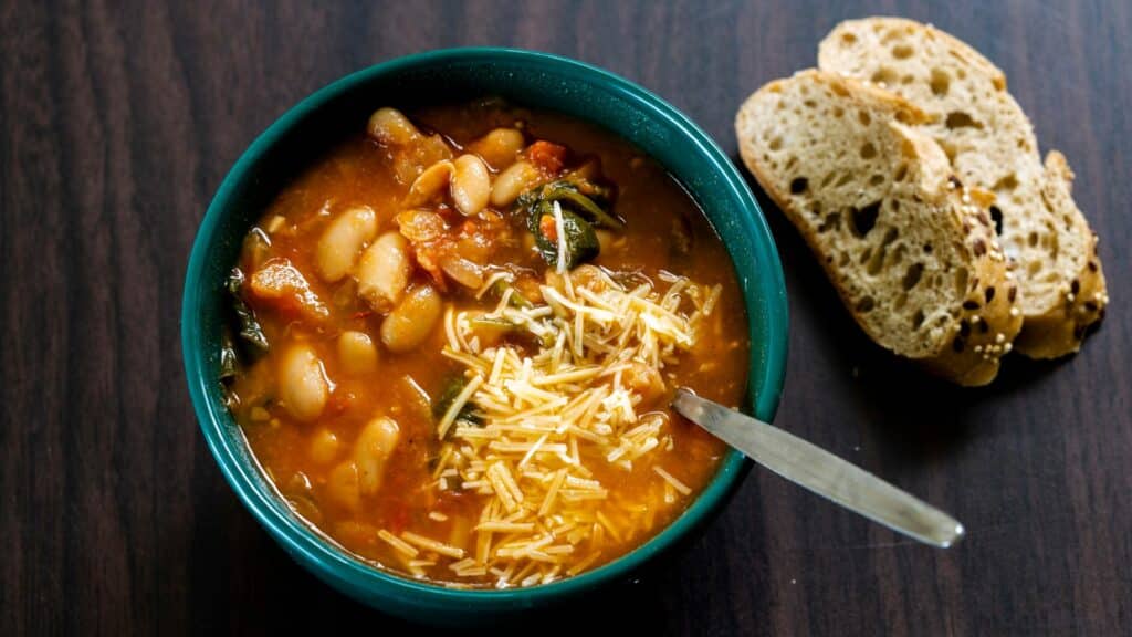 Bowl of vegetable bean soup with bread slices